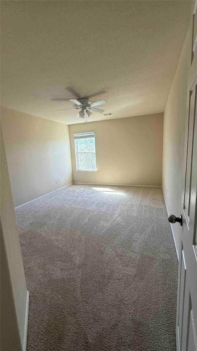 carpeted empty room featuring a textured ceiling and ceiling fan