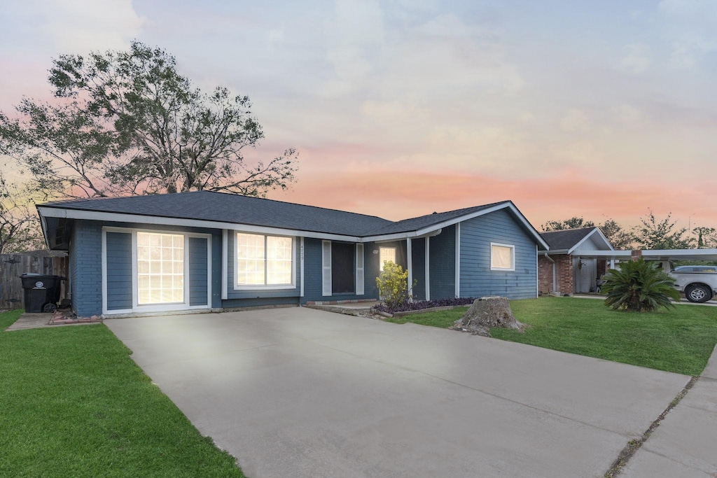 ranch-style home featuring a lawn