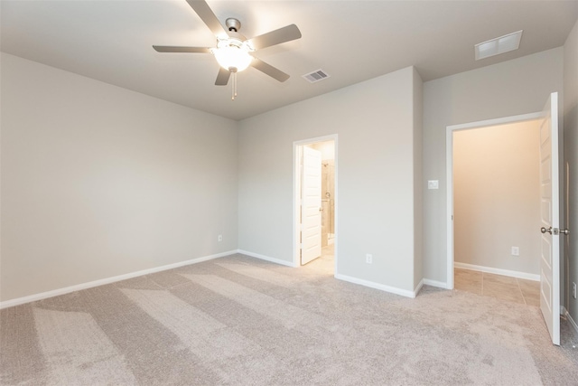 unfurnished bedroom featuring light carpet, ensuite bath, and ceiling fan