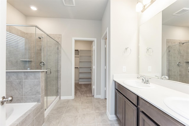 bathroom with tile patterned flooring, shower with separate bathtub, and vanity