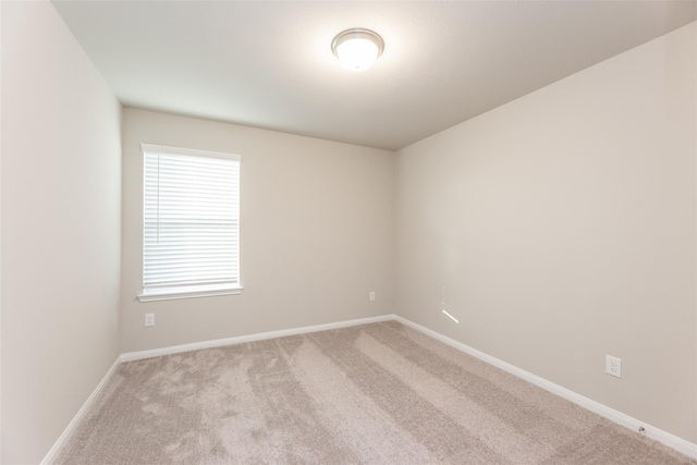 spare room featuring light colored carpet