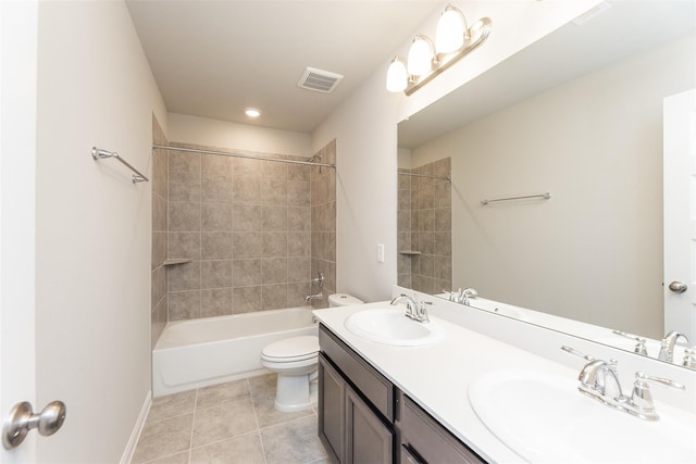 full bathroom featuring tile patterned flooring, vanity, tiled shower / bath combo, and toilet