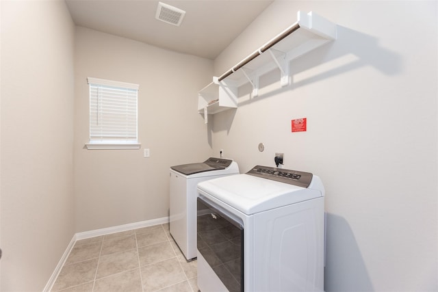 laundry room featuring separate washer and dryer and light tile patterned floors