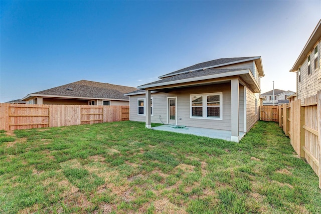 back of property with a patio area and a yard