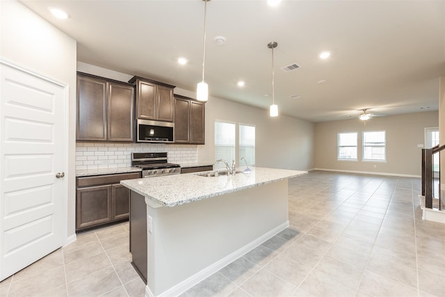 kitchen with decorative backsplash, appliances with stainless steel finishes, ceiling fan, sink, and decorative light fixtures