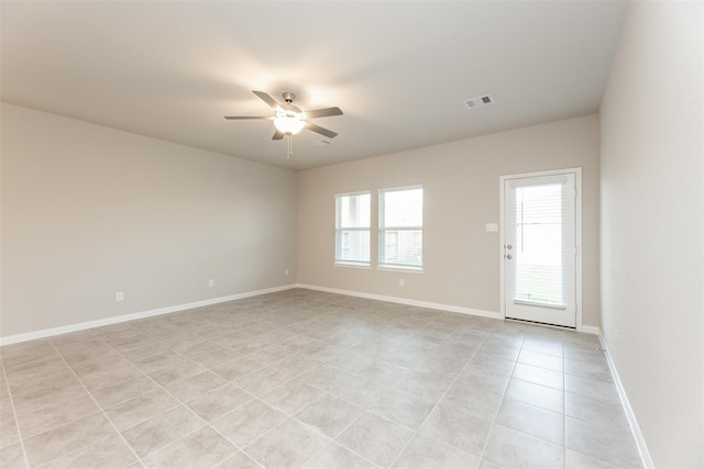 tiled empty room featuring ceiling fan