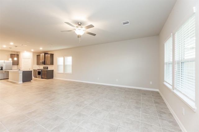 unfurnished living room with ceiling fan and light tile patterned floors