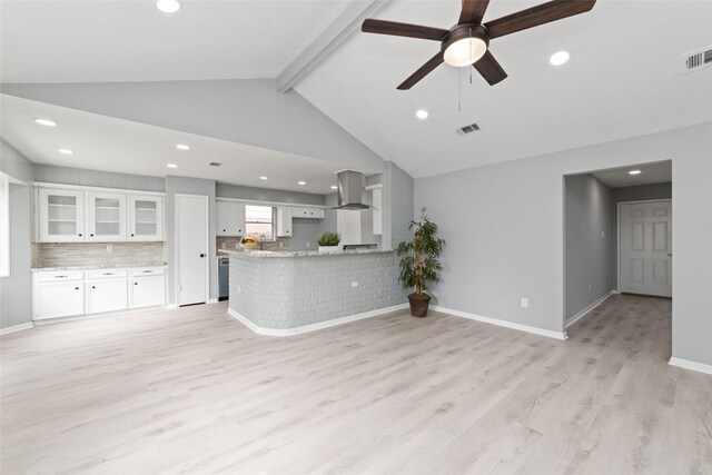 unfurnished living room featuring lofted ceiling with beams, light hardwood / wood-style floors, and ceiling fan