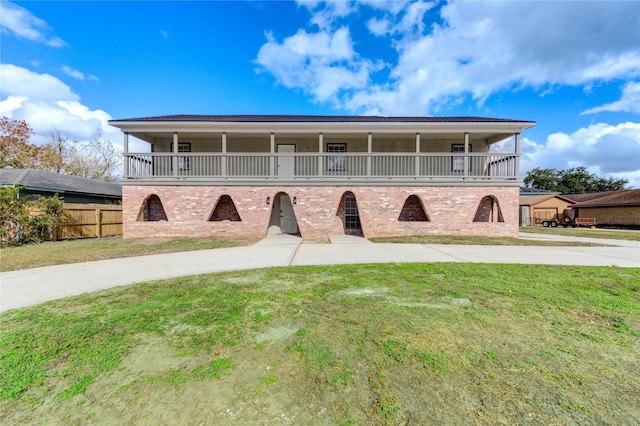 view of front of home with a balcony and a front yard