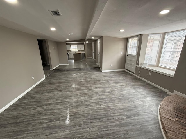 unfurnished living room featuring dark hardwood / wood-style flooring and beamed ceiling