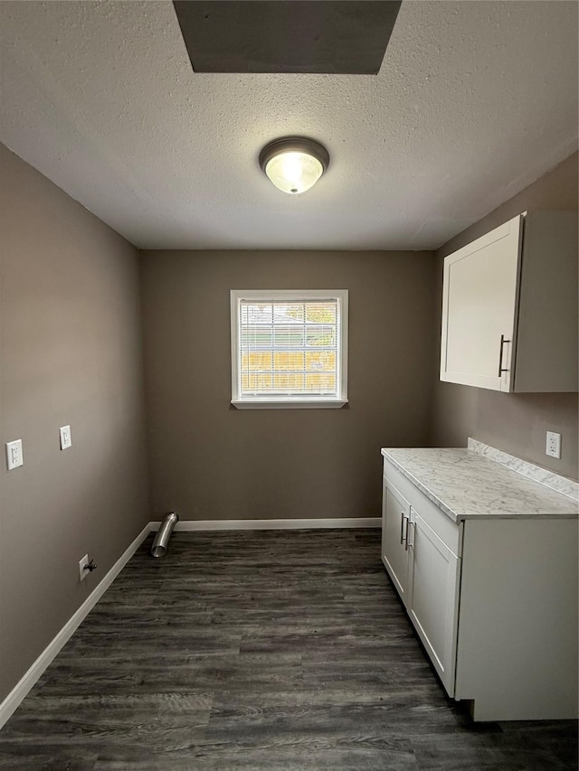 laundry room with cabinets, a textured ceiling, and dark hardwood / wood-style floors