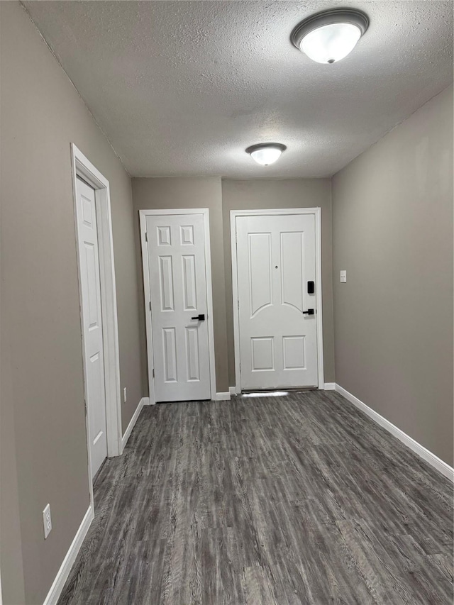 entrance foyer featuring a textured ceiling and dark hardwood / wood-style floors