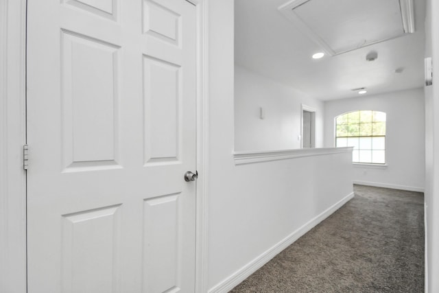 hall featuring dark colored carpet