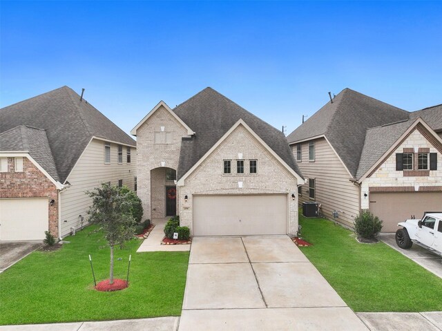 view of front of property with central AC unit, a garage, and a front yard