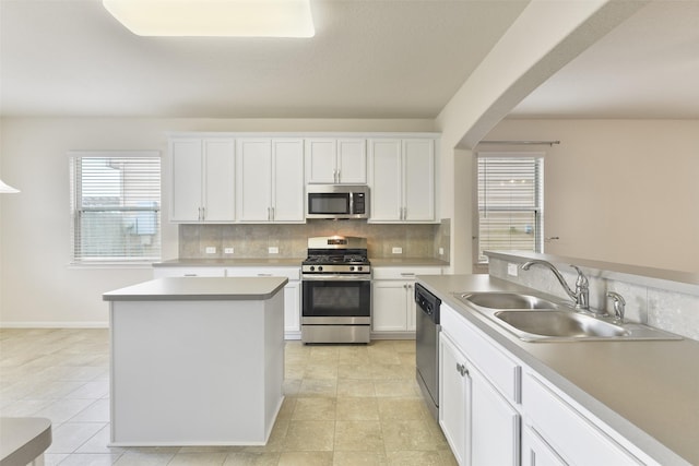 kitchen with stainless steel appliances, white cabinetry, and sink