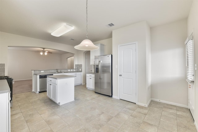 kitchen featuring a kitchen island, appliances with stainless steel finishes, pendant lighting, white cabinetry, and sink