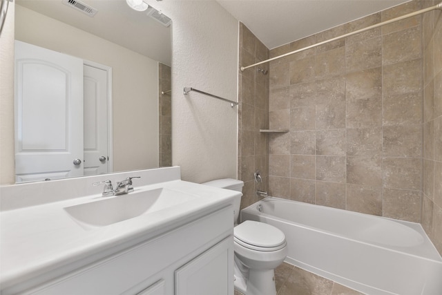 full bathroom with tiled shower / bath combo, vanity, tile patterned floors, and toilet