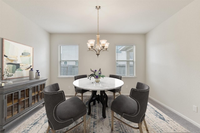 carpeted dining room featuring a notable chandelier