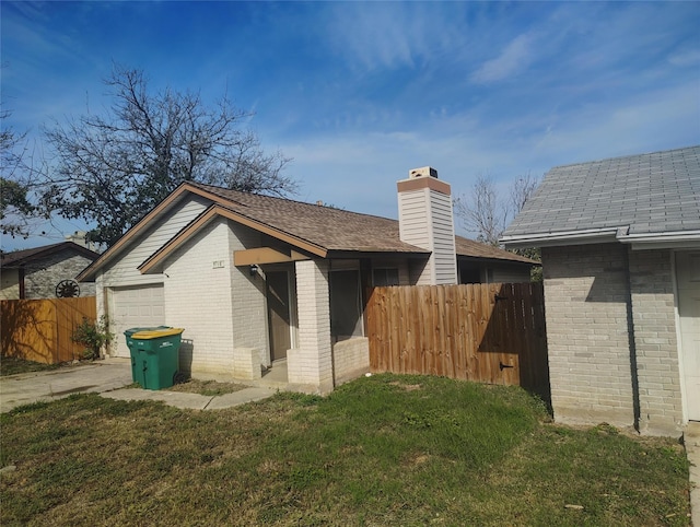 rear view of house with a lawn and a garage