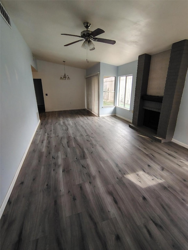 unfurnished living room featuring a fireplace, ceiling fan with notable chandelier, and hardwood / wood-style flooring