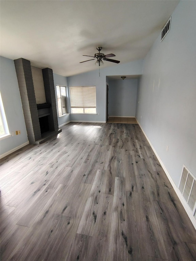 unfurnished living room featuring a fireplace, hardwood / wood-style flooring, ceiling fan, and lofted ceiling