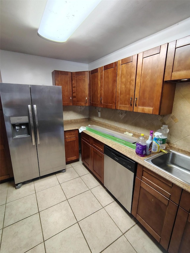 kitchen featuring decorative backsplash, appliances with stainless steel finishes, light tile patterned floors, and sink