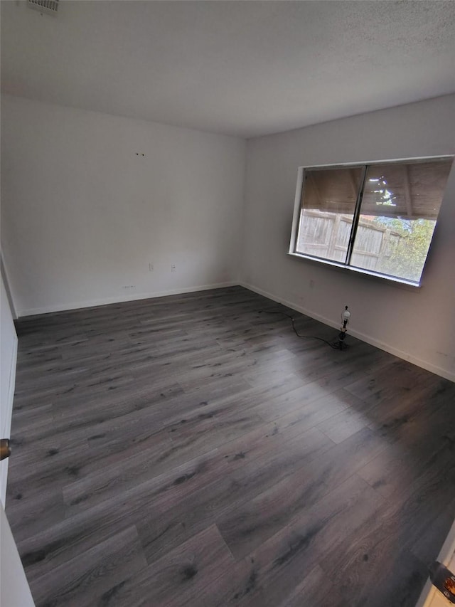 unfurnished room with dark hardwood / wood-style floors