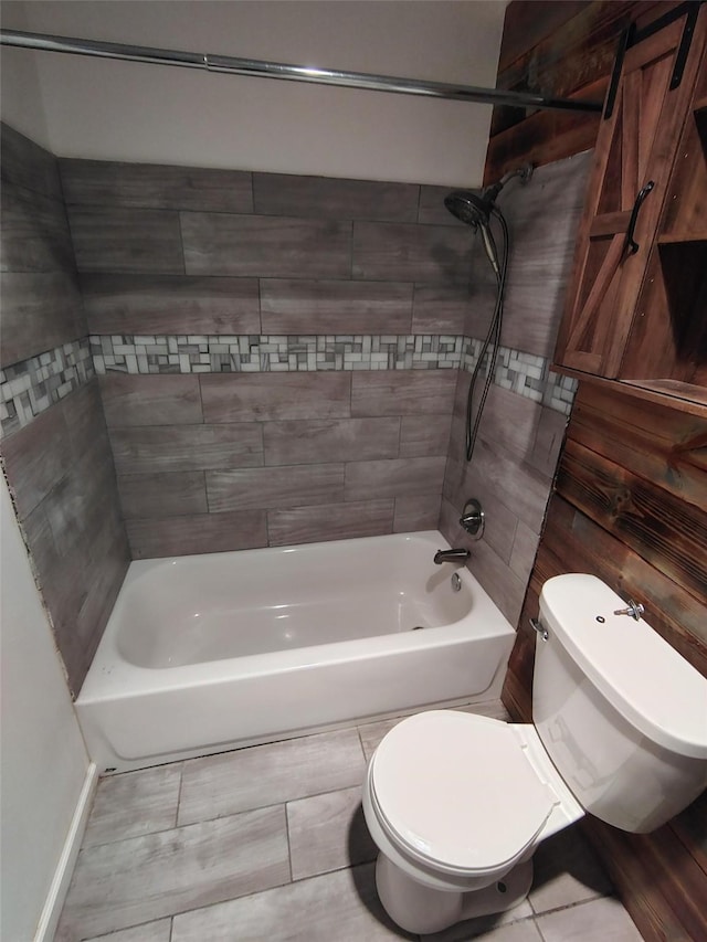 bathroom with toilet and tiled shower / bath