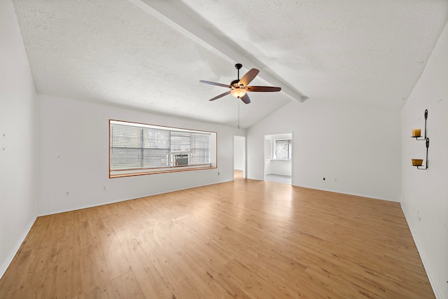 unfurnished room featuring lofted ceiling with beams, ceiling fan, a textured ceiling, and light hardwood / wood-style flooring