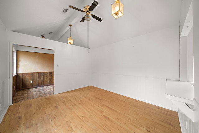 empty room featuring lofted ceiling with beams, light hardwood / wood-style floors, and ceiling fan