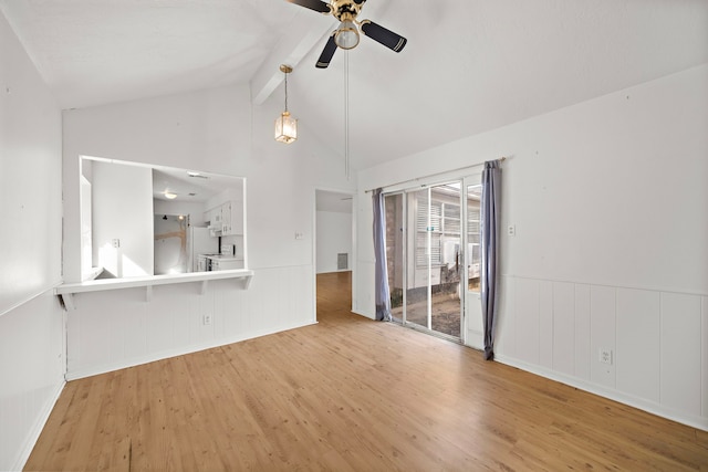 spare room featuring lofted ceiling with beams, light hardwood / wood-style floors, and ceiling fan