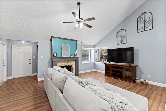 living room with hardwood / wood-style floors, ceiling fan, and high vaulted ceiling