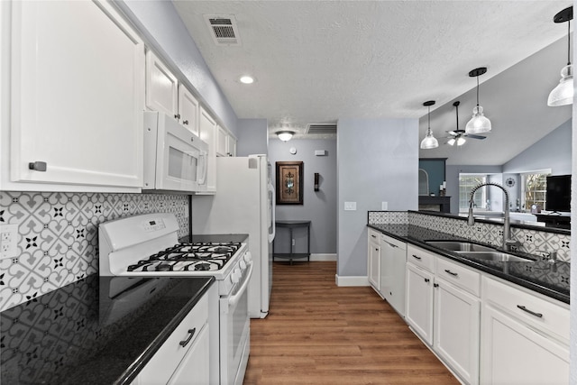 kitchen with white appliances, wood-type flooring, hanging light fixtures, ceiling fan, and white cabinetry