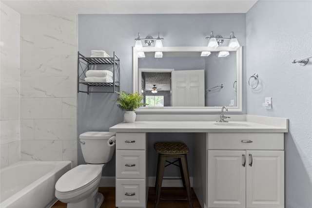 full bathroom featuring vanity, ceiling fan, toilet, and tiled shower / bath combo