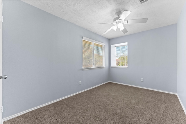 spare room featuring carpet flooring, ceiling fan, and a textured ceiling