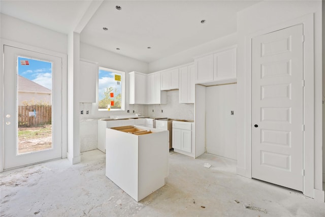 kitchen featuring white cabinets, a healthy amount of sunlight, and a kitchen island