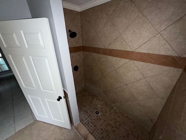 bathroom with tiled shower, tile patterned floors, and crown molding