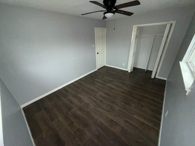 unfurnished bedroom featuring a closet, ceiling fan, and dark hardwood / wood-style flooring