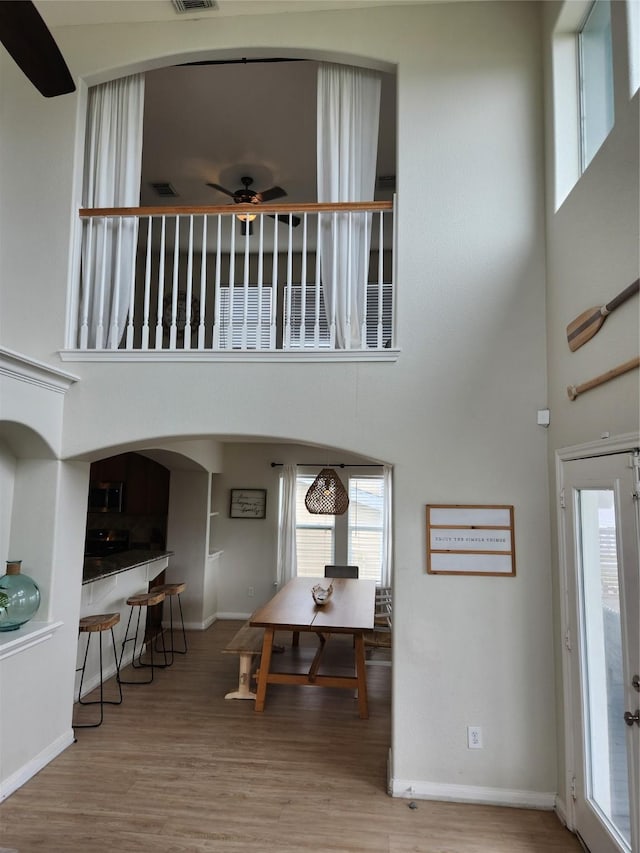 foyer entrance with a high ceiling, hardwood / wood-style flooring, and ceiling fan