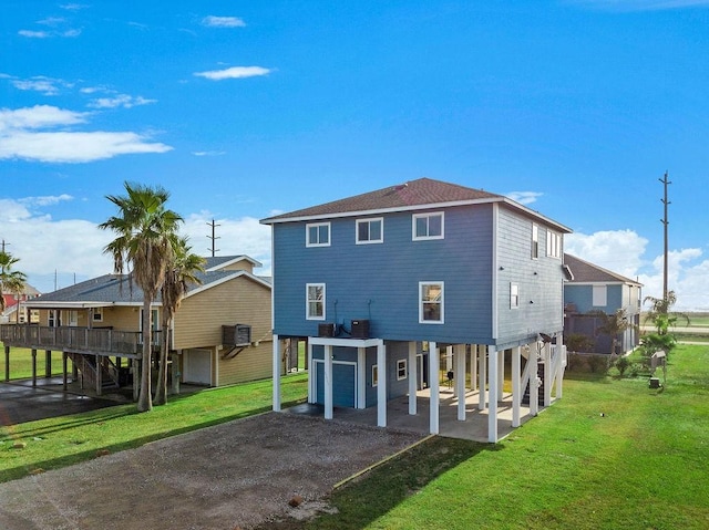 22901 Buena St, Galveston, TX 77554 - rear view of property with central AC, a garage, a carport, and a lawn
