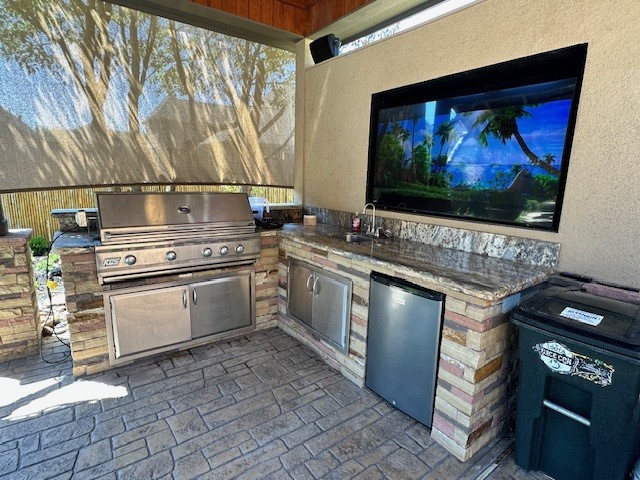 view of patio / terrace featuring exterior kitchen, sink, and grilling area