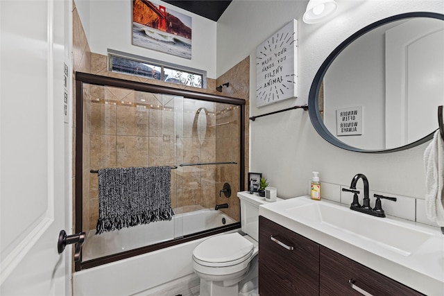 full bathroom featuring enclosed tub / shower combo, vanity, and toilet