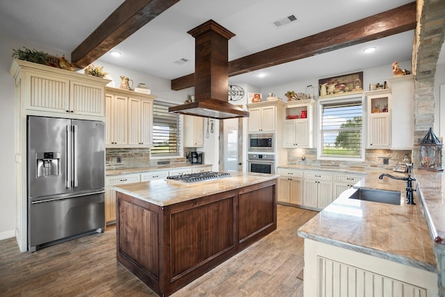 kitchen featuring light stone countertops, appliances with stainless steel finishes, tasteful backsplash, sink, and beam ceiling