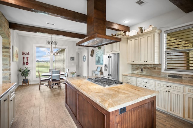 kitchen featuring cream cabinets, light hardwood / wood-style floors, appliances with stainless steel finishes, a kitchen island, and island exhaust hood