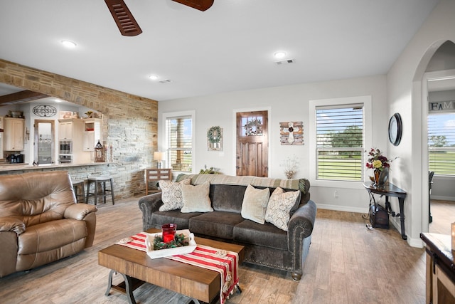 living room featuring ceiling fan, a wealth of natural light, and light hardwood / wood-style flooring