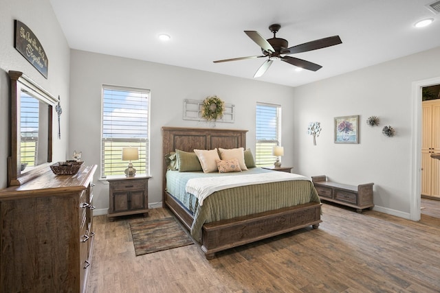 bedroom featuring hardwood / wood-style floors, multiple windows, and ceiling fan