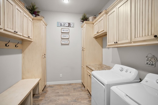 laundry room with separate washer and dryer, cabinets, and light hardwood / wood-style floors