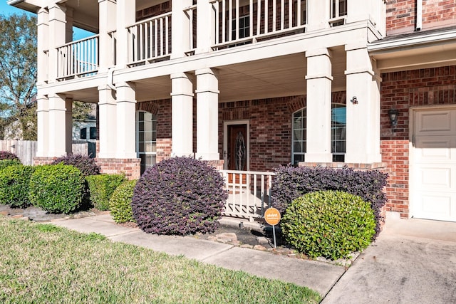 view of exterior entry with a balcony