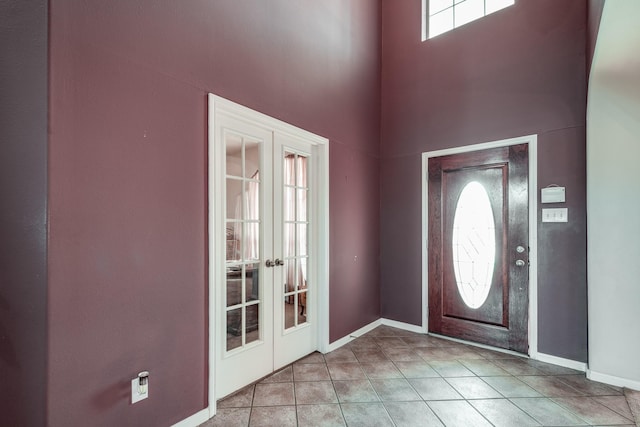 tiled foyer entrance with a towering ceiling and french doors