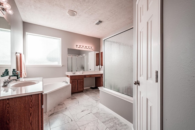 bathroom with plus walk in shower, vanity, and a textured ceiling